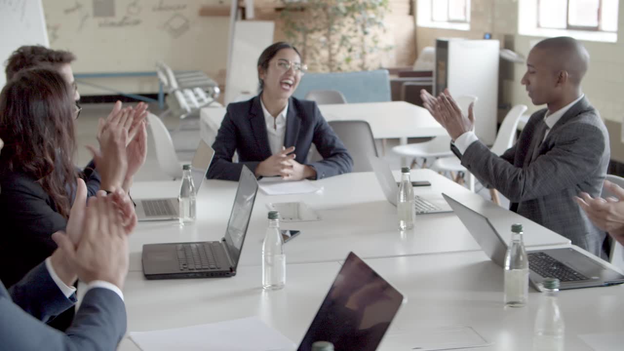 부하들이 성공적인 아시아 스피커를 박수를 치고 있습니다.