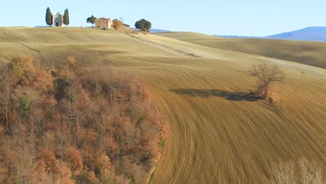 a beautiful farmhouse and church in the distance in tuscany italy