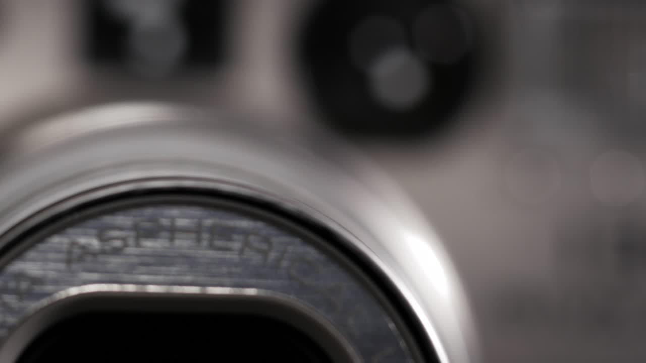 Macro rack focus on silver 35mm point and shoot lens as zoom moves