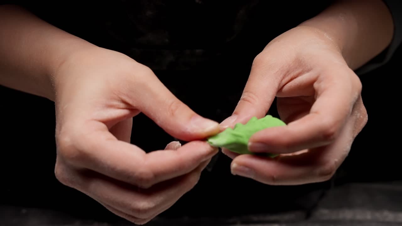 Close-up of Hands Shaping Green Dough for Pasta or Dumplings