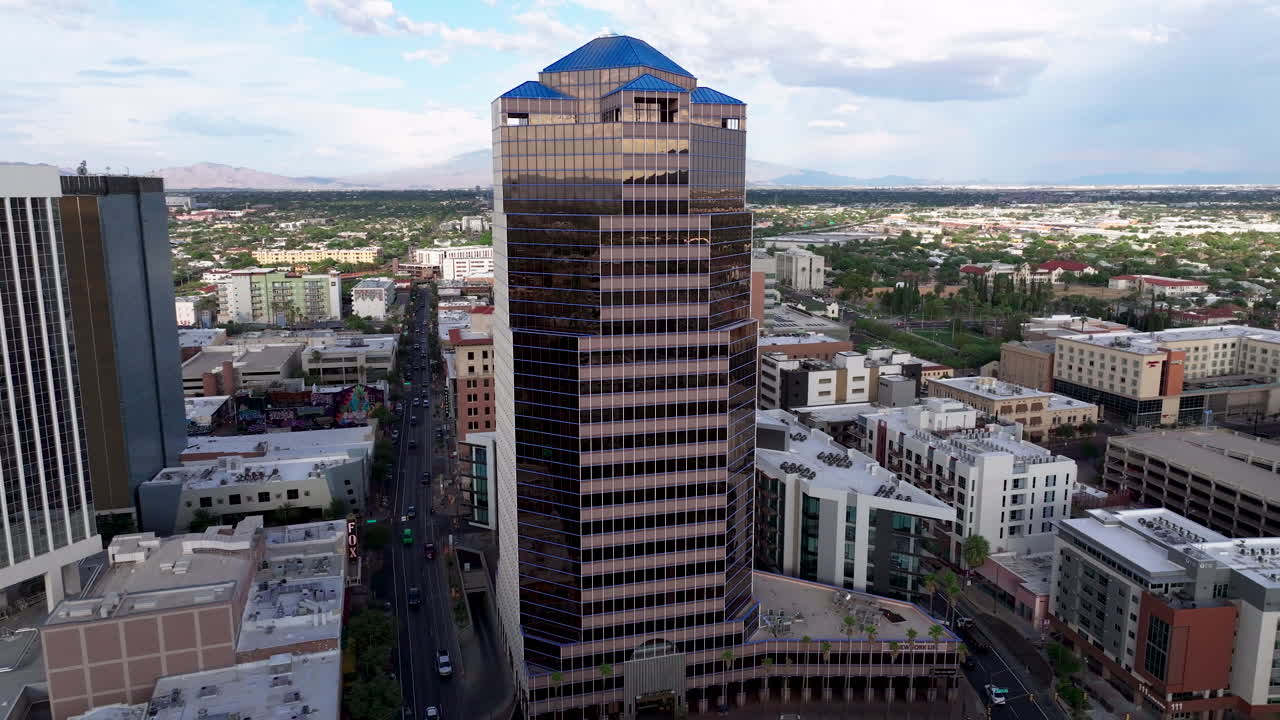 4k, 넓은 공중  ⁇ 이 터슨 시내의 건물에 내려오는 동안 날고, 배경에 산과 도시를 둘러싼 az