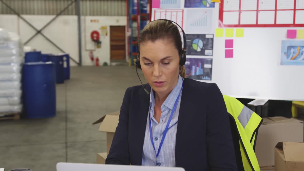 mujer joven trabajando en un escritorio en un almacén 4k