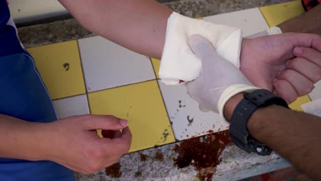 rescuer emergency helping a teenager with a bleeding wound, using bandages and gloves