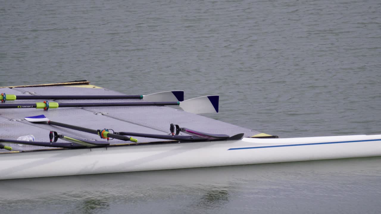 Pier on the water with oars and modern double sculls