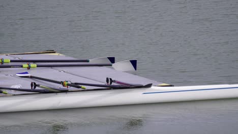 pier on the water with oars and modern double sculls