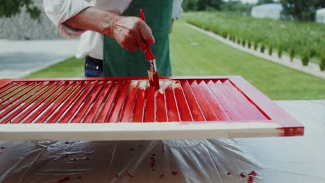 painting garden shutters and a senior gardener