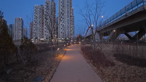 twilight view along paved path at songdo moonlight festival park in incheon, south korea. pov, wide shot