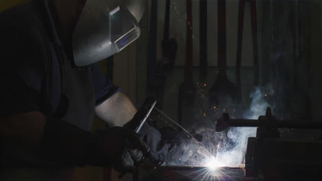 Caucasian-male-factory-worker-at-a-factory-standing-in-a-workbench,-welding