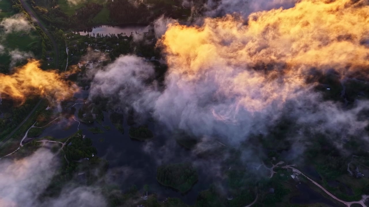 Sunshine illuminates clouds from above, vibrant sky and landscape beneath.