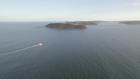 Boat-Cruising-In-The-Calm-Sea-Towards-The-Barrenjoey-Headland-In-Palm-Beach,-NSW,-Australia