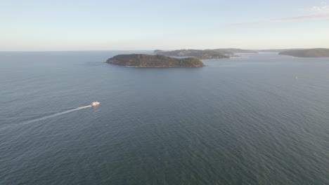 Barco-De-Crucero-En-El-Mar-En-Calma-Hacia-El-Promontorio-Barrenjoey-En-Palm-Beach,-Nueva-Gales-Del-Sur,-Australia