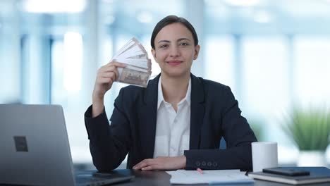 mujer de negocios india usando dinero como admirador rico