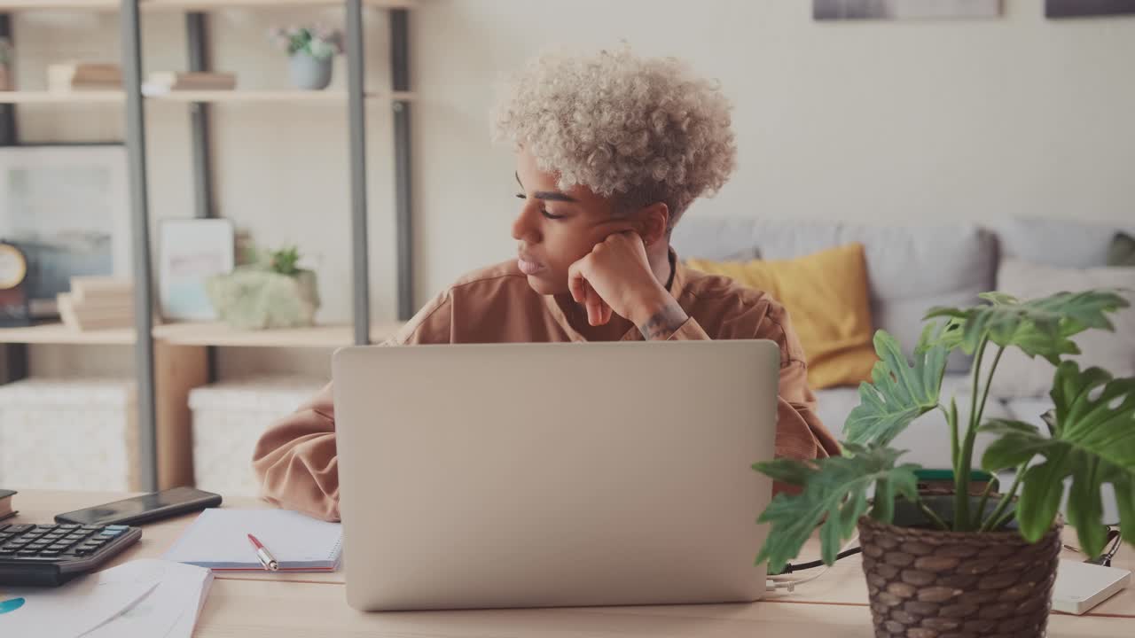 Woman works remotely at laptop from home wanting go to work in office