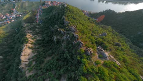 Fpv-Volando-Bajo-Sobre-Las-Antiguas-Ruinas-Del-Castillo-En-La-Cima-De-La-Formación-De-Montañas-Rocosas,-Dürnstein,-Austria