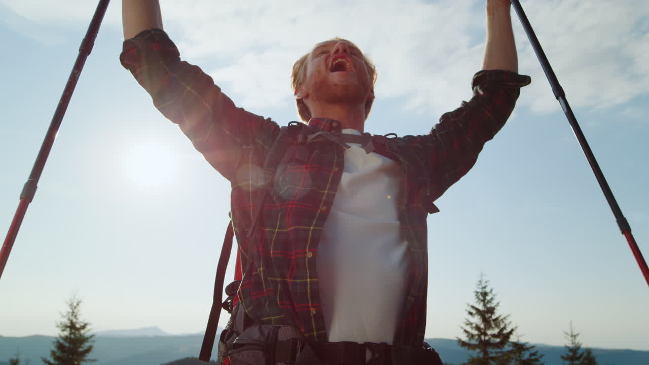 트레킹 막대기 를 들고 손 을 들고 축하 하는 행복 한 산책자