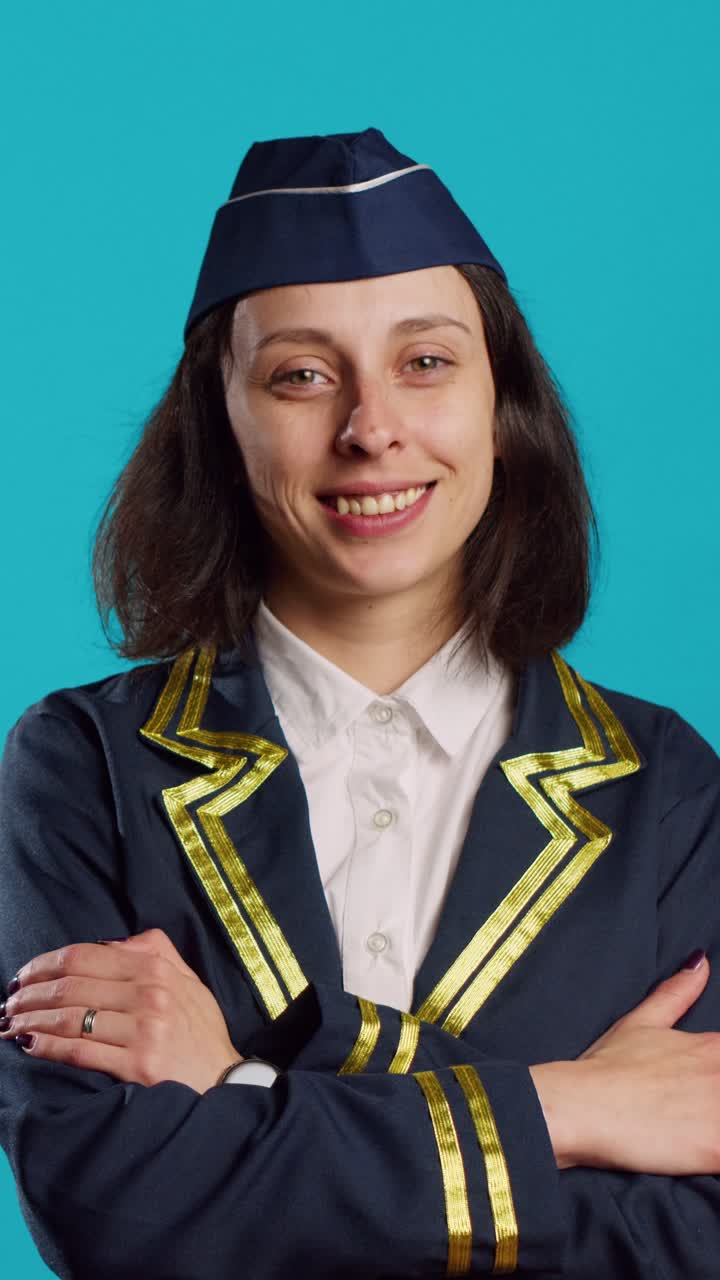 Vertikální video: Sebevědomá mladá letuška pózuje v letecké uniformě