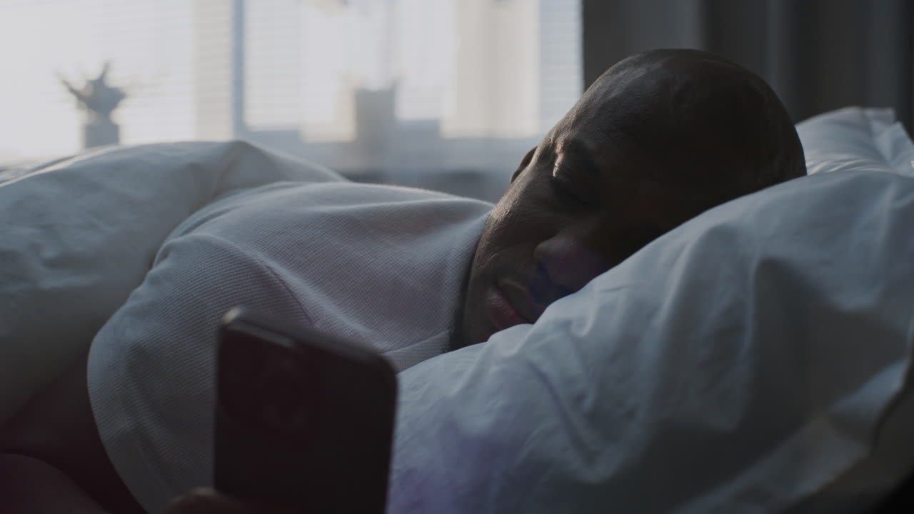 hombre usando el teléfono en la cama