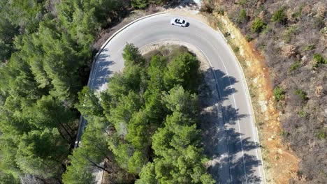 Weißes-Auto,-Das-Auf-Einer-Bergstraße-Mit-Wald-In-Der-Nähe-Abbiegt