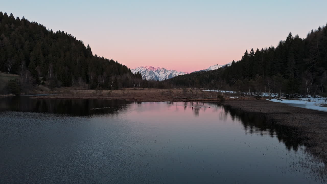 Sereno lago delle Alpi Svizzere al tramonto, riflesso calmo, paesaggio tranquillo