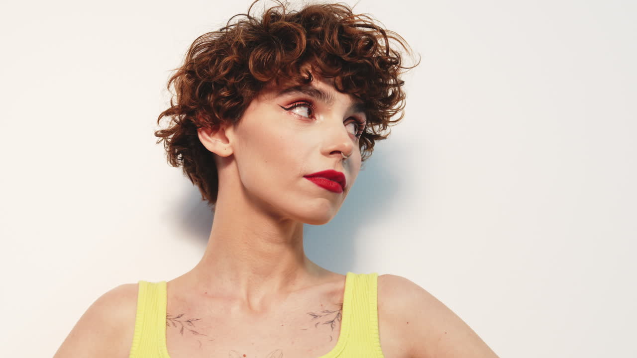 mujer con el cabello rizado y la parte superior amarilla