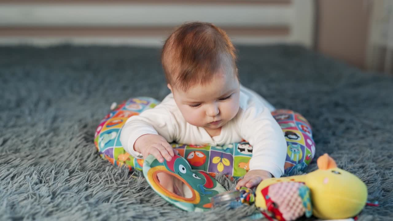 お腹の上に横たわって遊んでいる小さな女の赤ちゃん