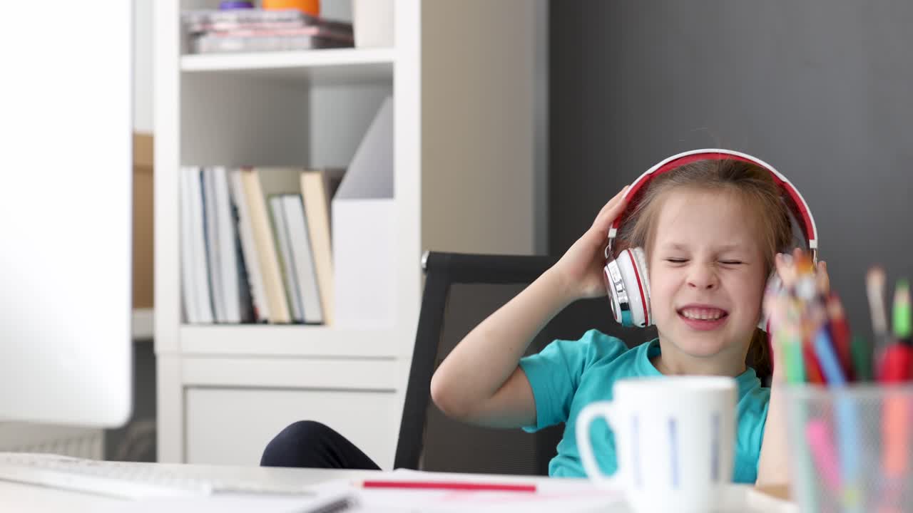 Bambino frustrato che urla con le cuffie a una scrivania