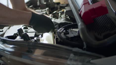 Mechanical-Guy-Wearing-Black-Gloves-Unscrewing-Bolt-To-Remove-Electric-Car-Battery