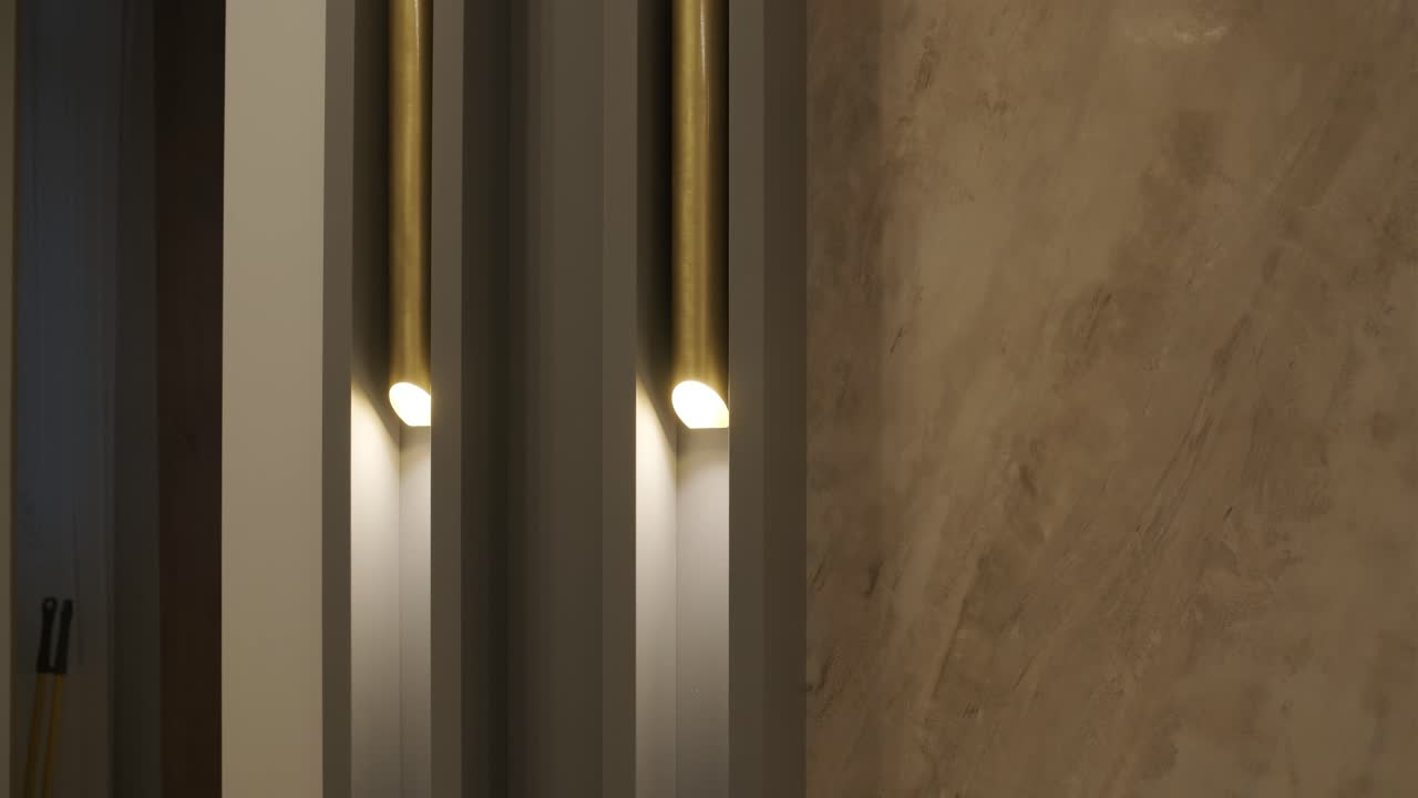 juego abstracto de luz y sombra con iluminación vertical moderna contra paredes texturizadas, creando un ambiente cálido