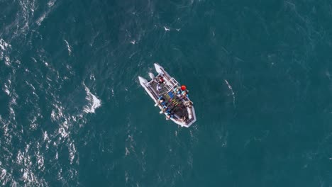 drone, aerial shot of scuba divers jump, make a backroll entry from a diving boat