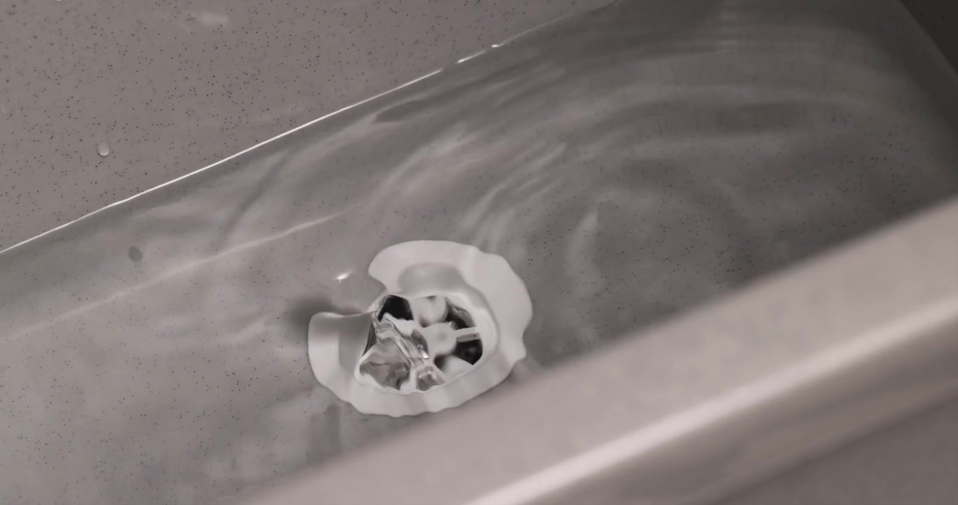 Close-up of a Caucasian male hand pulling a white plug from a grey sink, with water overflowing, 4K