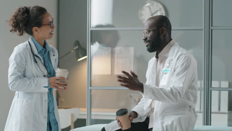 multiethnic doctors chatting over coffee in clinic