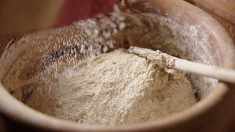 baking - sprinkling flour on the batter, sourdough bread, slow motion close up