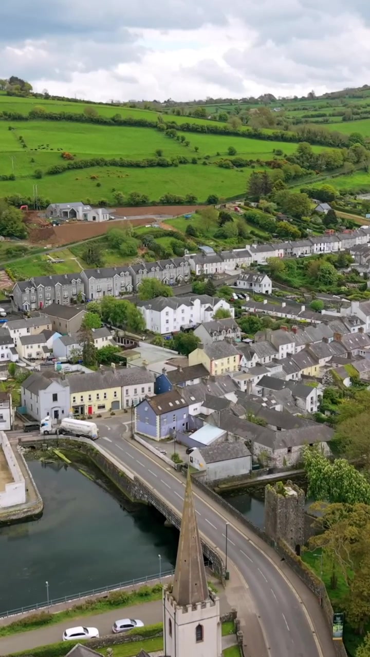 Video aereo in formato verticale per social media della città di Glenarm, sulla Causeway Coastal Route nella Contea di Antrim, Irlanda del Nord, nel Regno Unito, in una giornata di sole. Prodotto in 3840x2160 e con colore Rec709