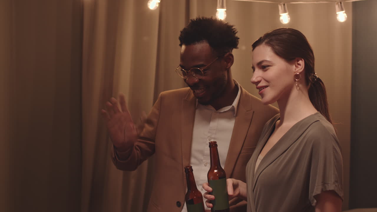 Multi-etnisk par med ølglas til houseparty