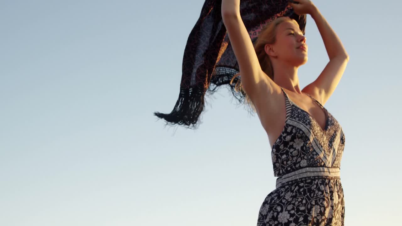 해변 에 스카프 를 입고 서 있는 여자