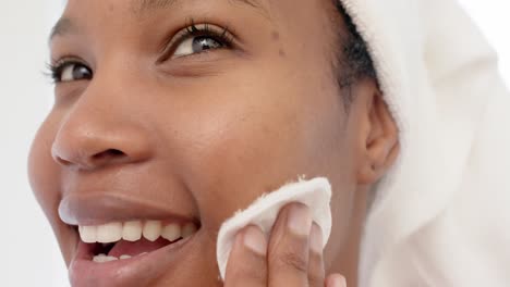 Happy-biracial-woman-with-towel-on-head-washing-her-face,-slow-motion