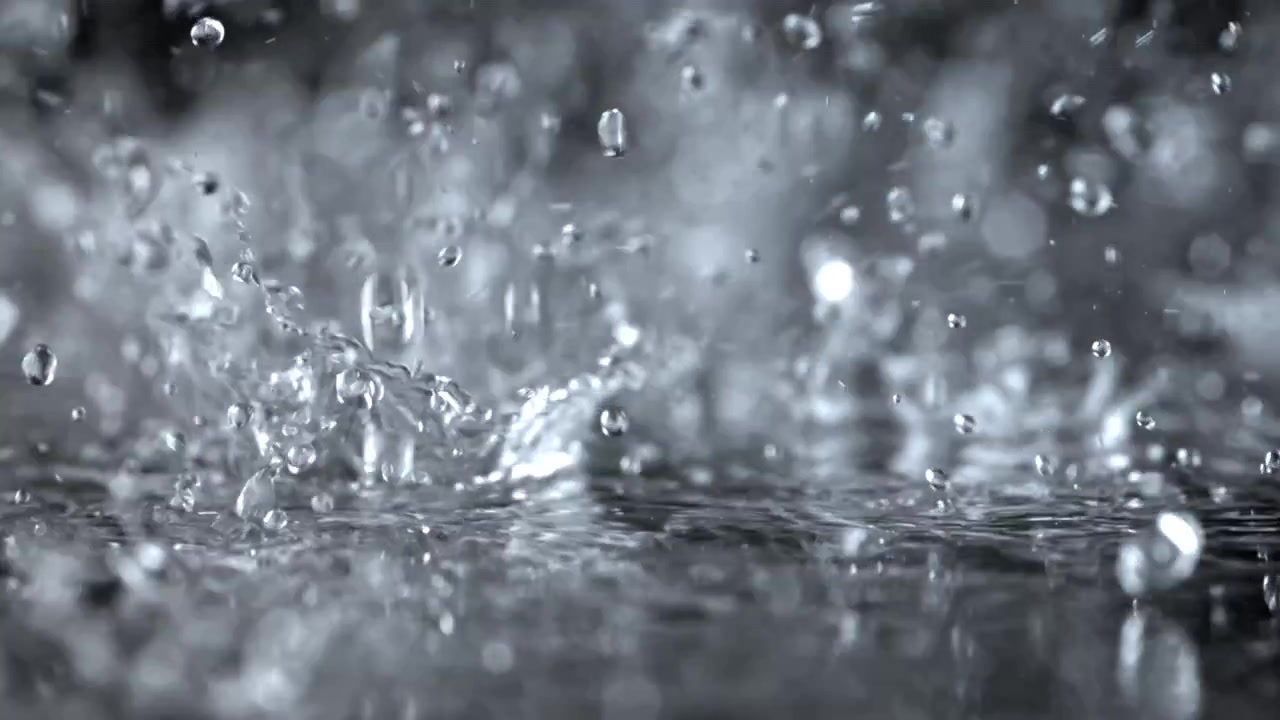 Zeitlupe: Wassertropfen spritzen auf eine nasse Oberfläche