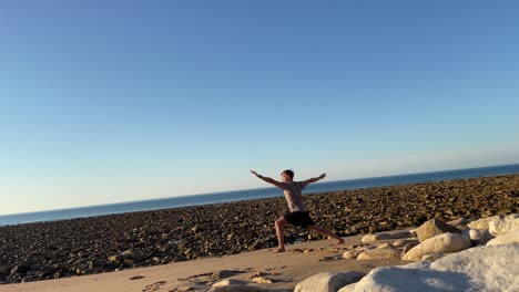 joven haciendo movimientos de yoga frente al océano atlántico en una playa vacía