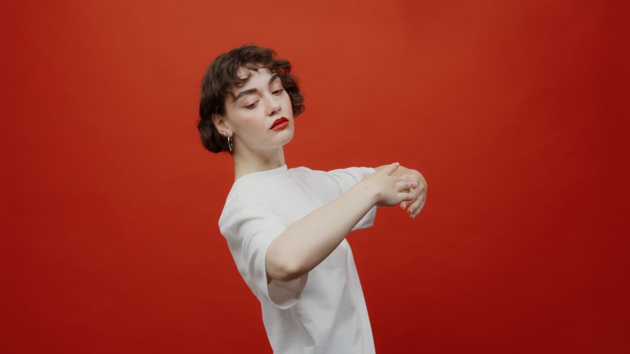 색 티셔츠를 입고 빨간색 배경에 포즈를 취하는 여자