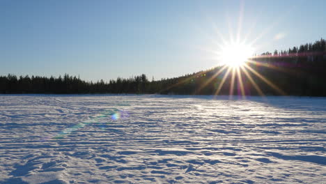 Verschneite-Landschaft-Mit-Untergehender-Sonne,-Zugefrorener-See-In-Lappland