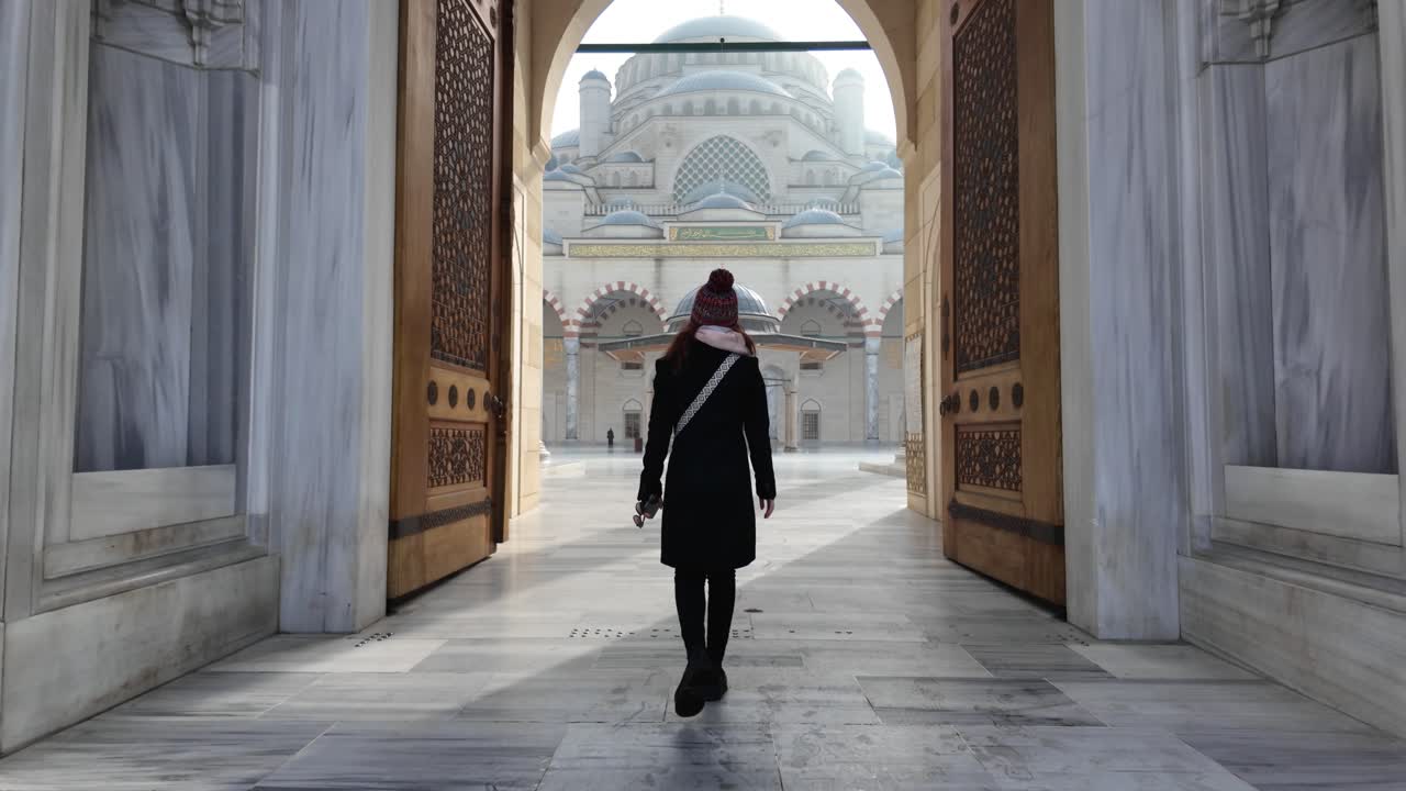 Slow Motion of a Female traveler entering Istanbul's iconic Camlica mosque gate in Turkey on a sunny day