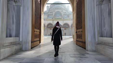 slow motion of a female traveler entering istanbul's iconic camlica mosque gate in turkey on a sunny day