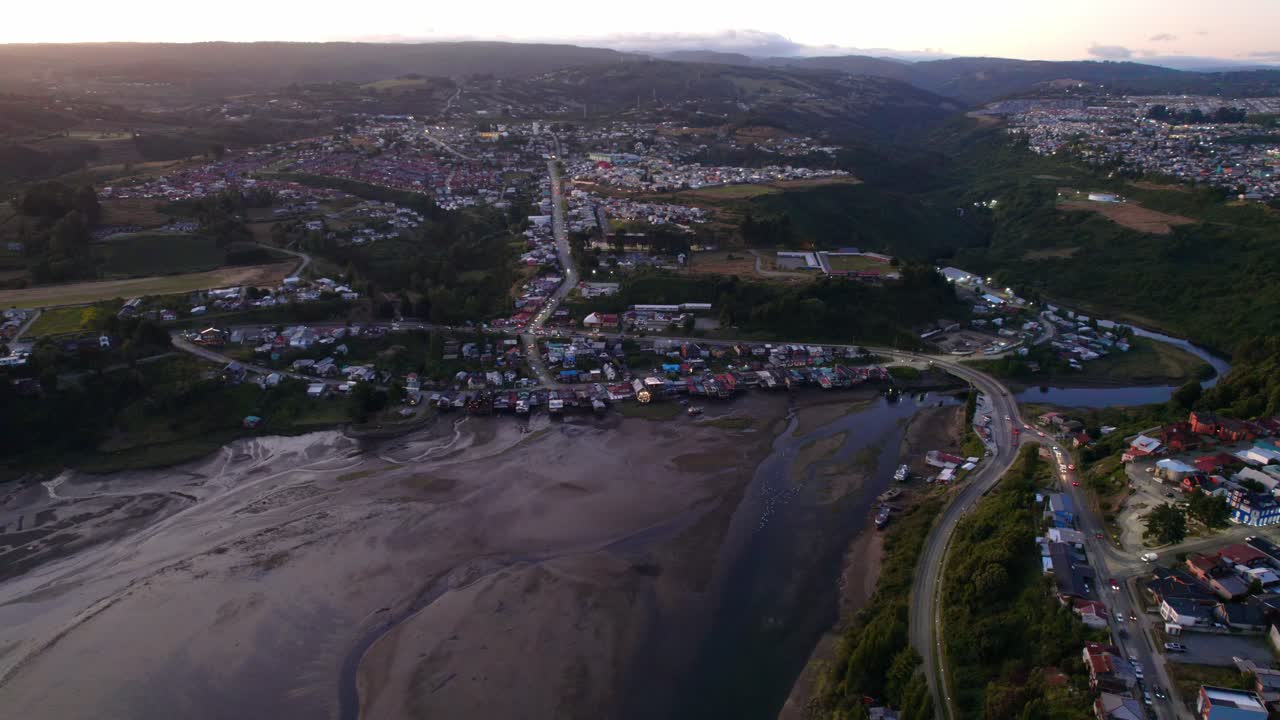 vista aérea de la pintoresca ciudad de castro durante la hora azul del atardecer, toma en órbita