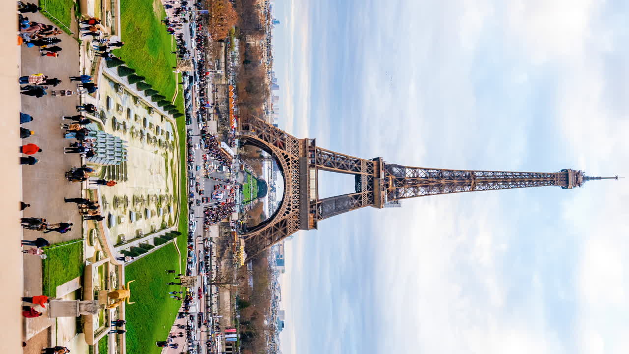 Parigi, Francia - 4 gennaio 2023: auto e persone in movimento per strada sotto la Torre Eiffel a Champ de Mars. Verticale