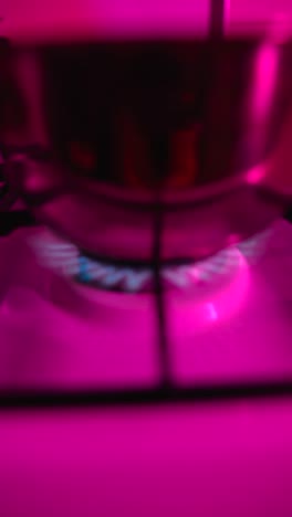 boiling water on a stovetop with pink lighting