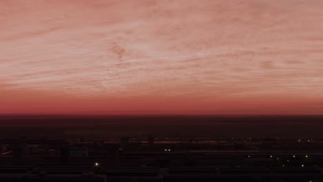 Drone-zoomed-shot-surreal-juxtaposition-as-a-blood-red-sky-looms-over-a-grim,-industrial-landscape-4K50Fps-cinematic-grade