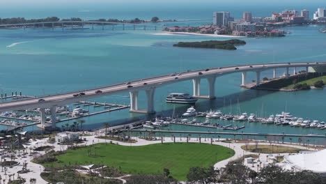 drone view of coachman park in downtown clearwater then ascending to follow causeway to beach