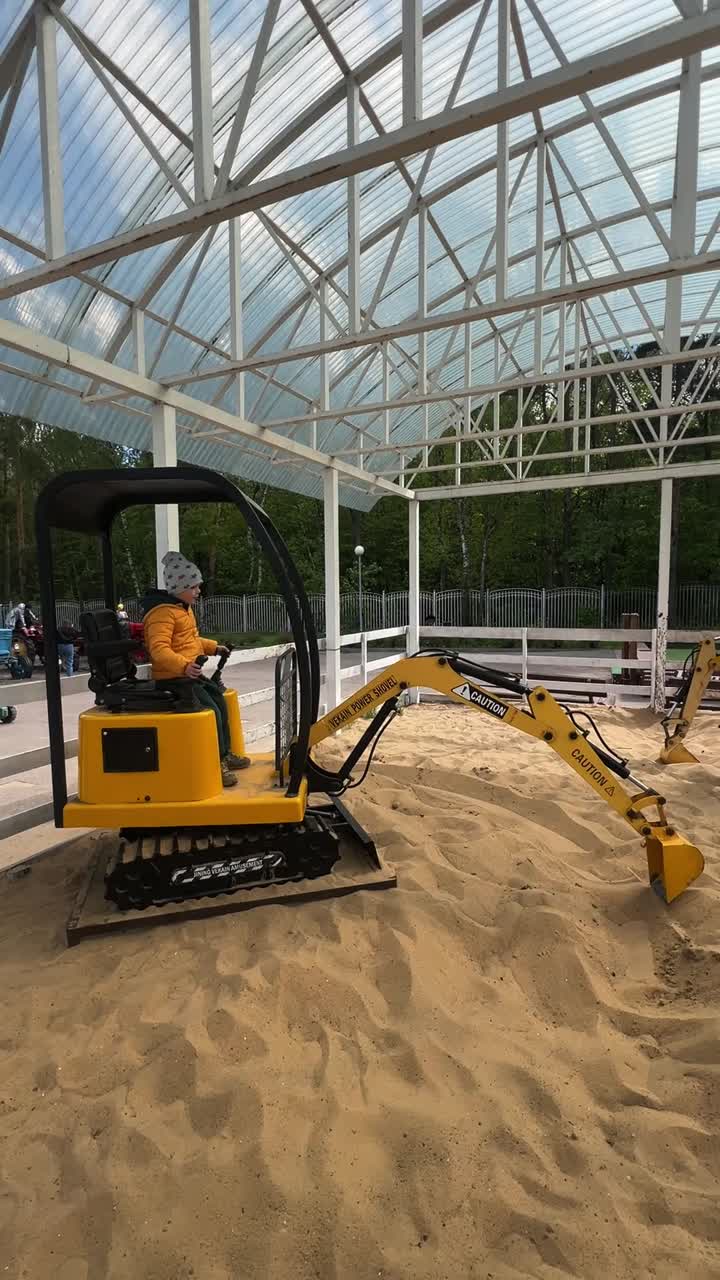 Child Playing with a Toy Excavator in a Sandbox