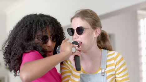 Felices-Y-Diversas-Amigas-Adolescentes-Bailando-Y-Cantando-Con-Gafas-En-Casa,-Cámara-Lenta