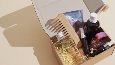 video of beauty products in cardboard box with copy space over brown background